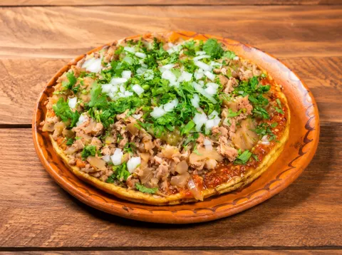 Picada gigante de salsa roja con carnitas en Shory's Tacos JR